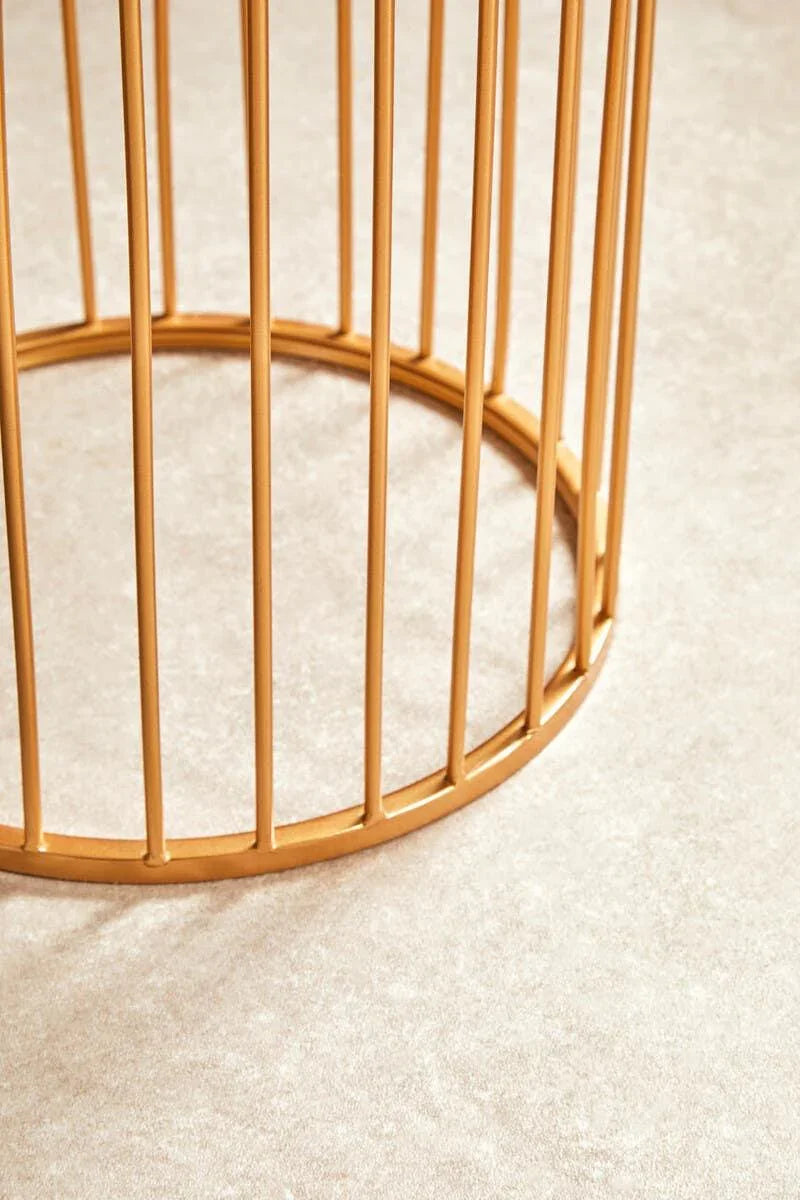 Gold metal coffee table base detail on beige carpet