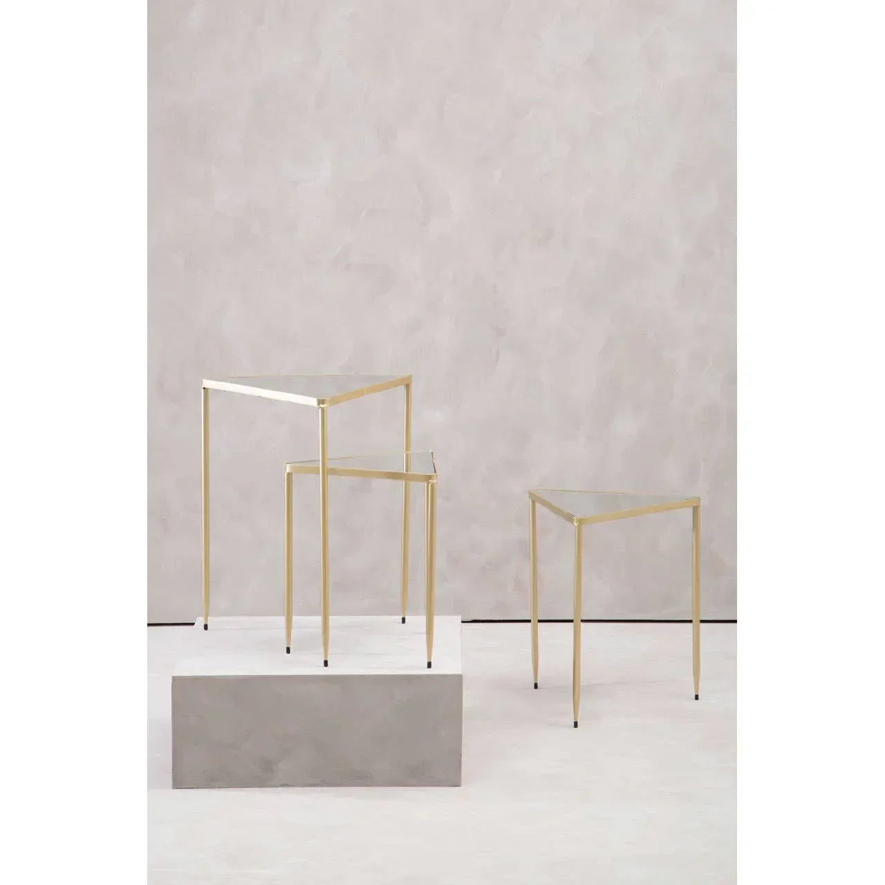 Set of three glass top side tables with slim gold metal frames in staggered heights