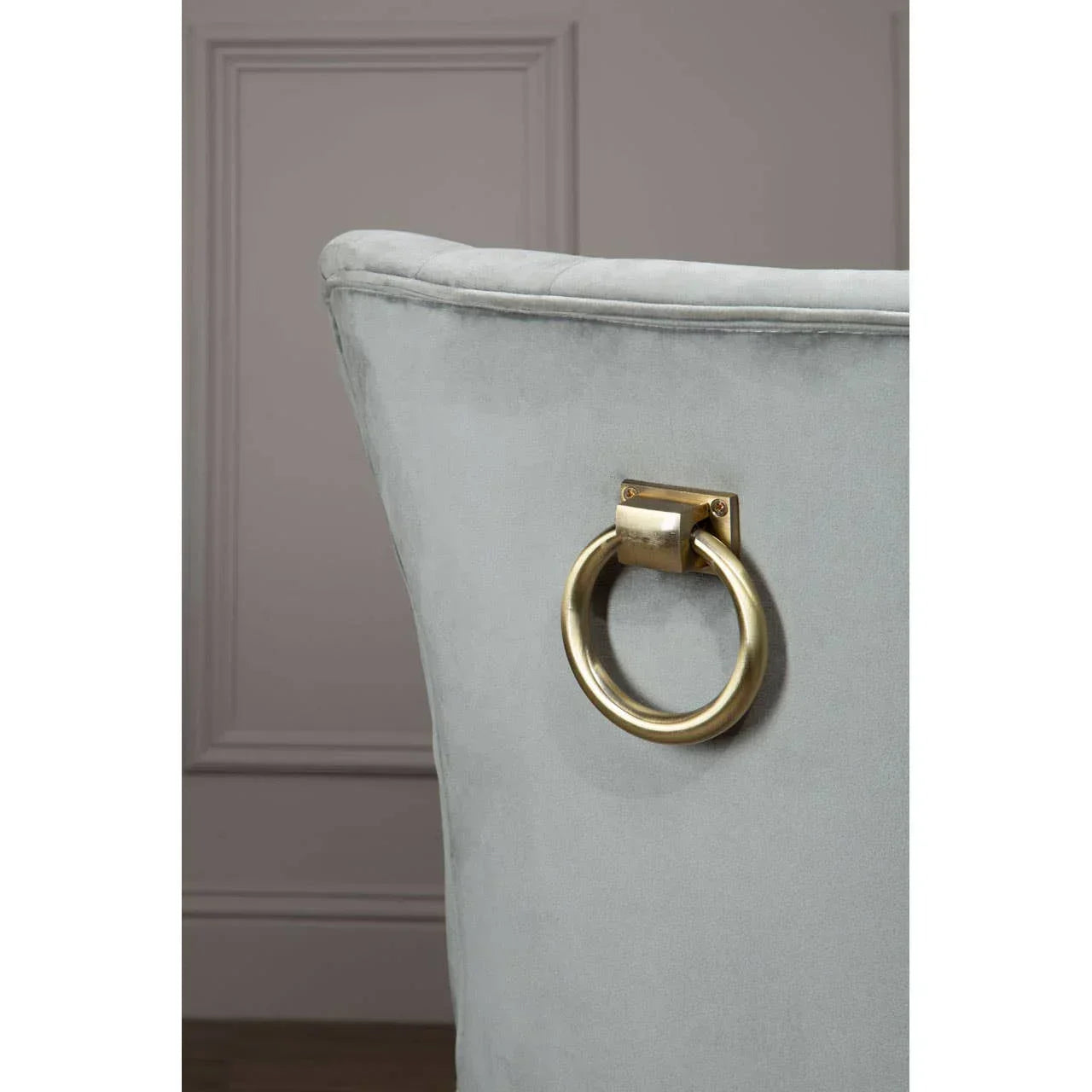 Light grey velvet dining chair back with gold metal knocker handle detail