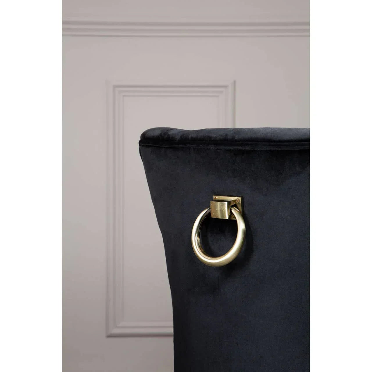 Black velvet dining chair with gold metal ring handle detail on backrest