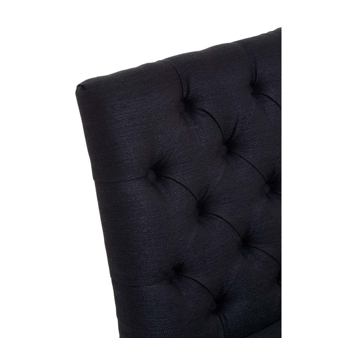 Close-up of black fabric tufted dining chair backrest with button detail