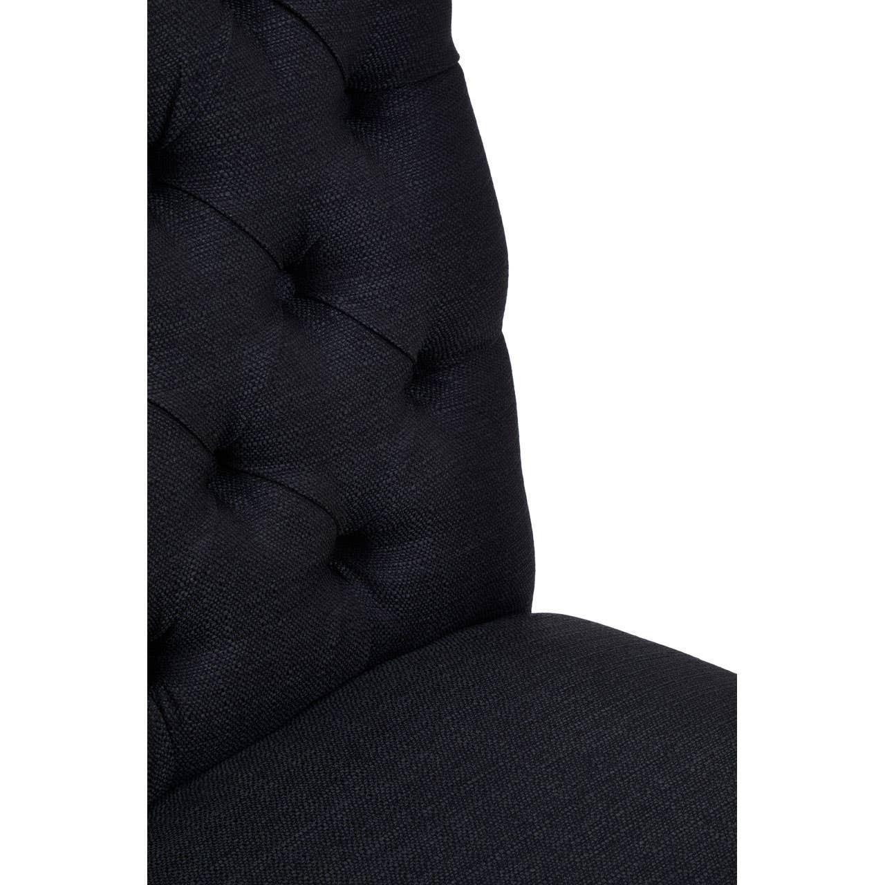 Closeup of dark fabric upholstered dining chair with button-tufted backrest