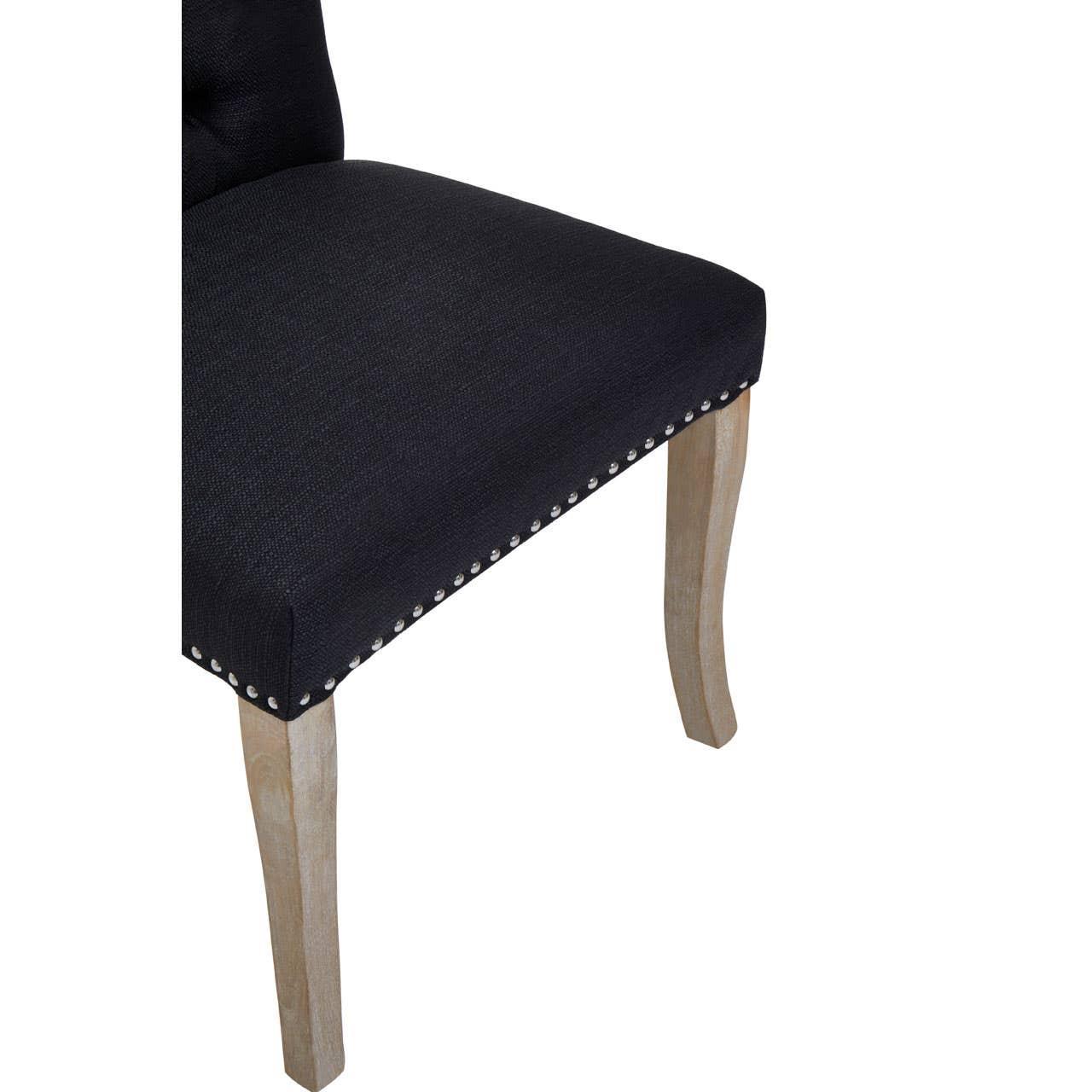 Black upholstered dining chair seat with nailhead trim and light wood legs