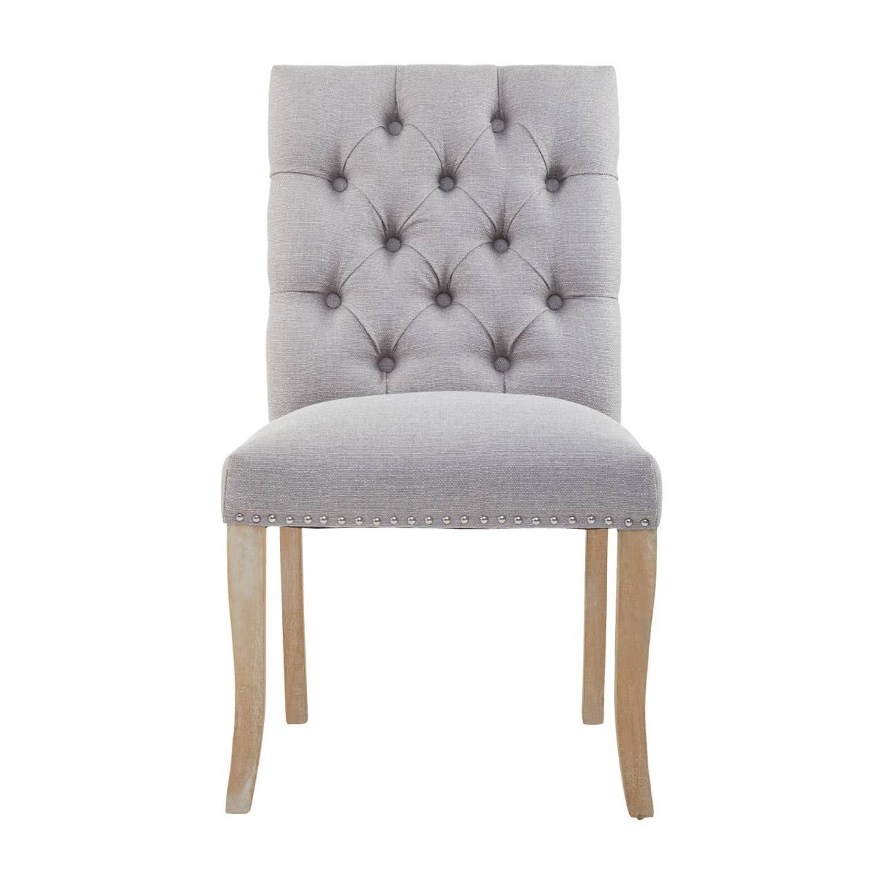 Grey upholstered dining chair with button tufted back and wooden legs, front view