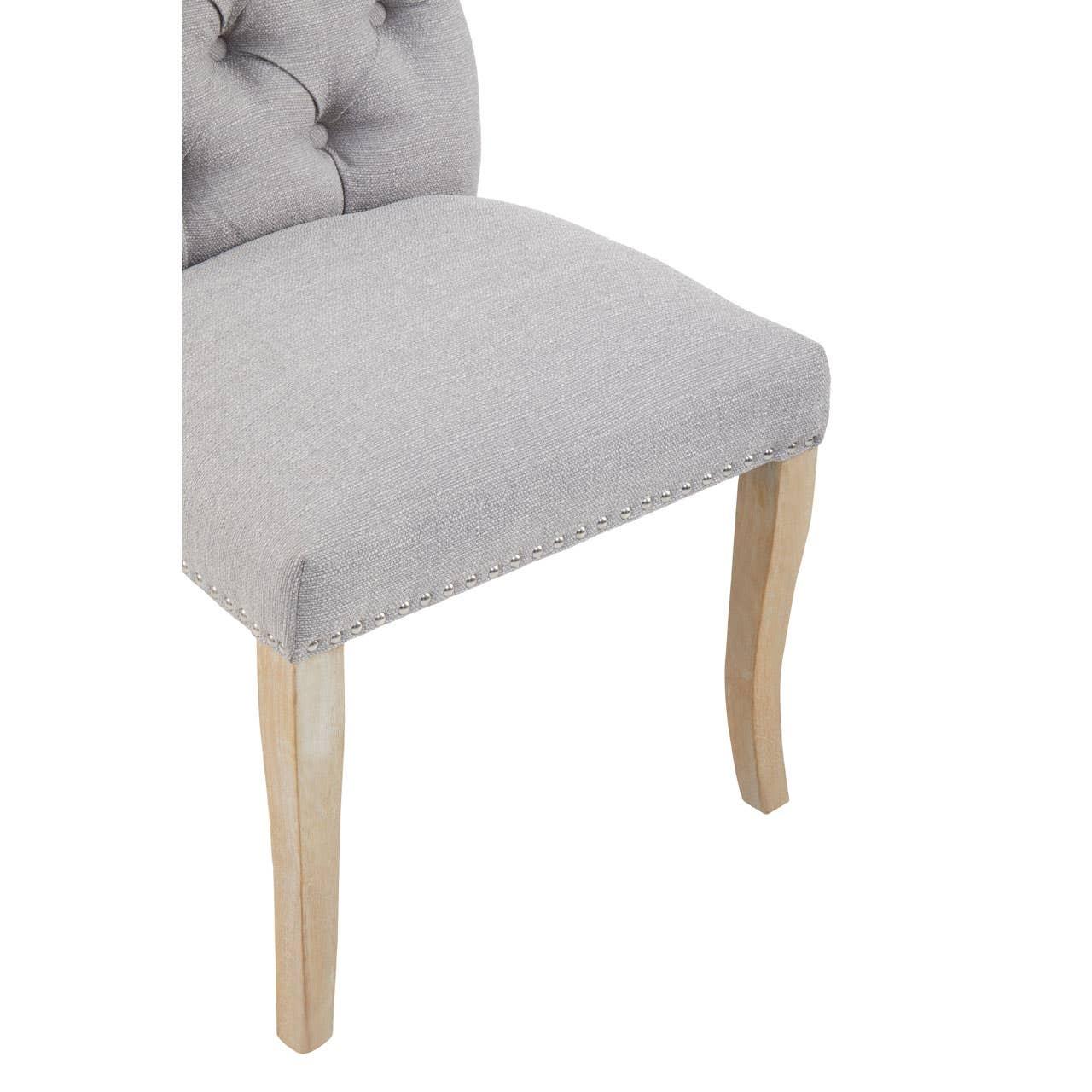 Light grey fabric dining chair with studded trim and natural wooden legs