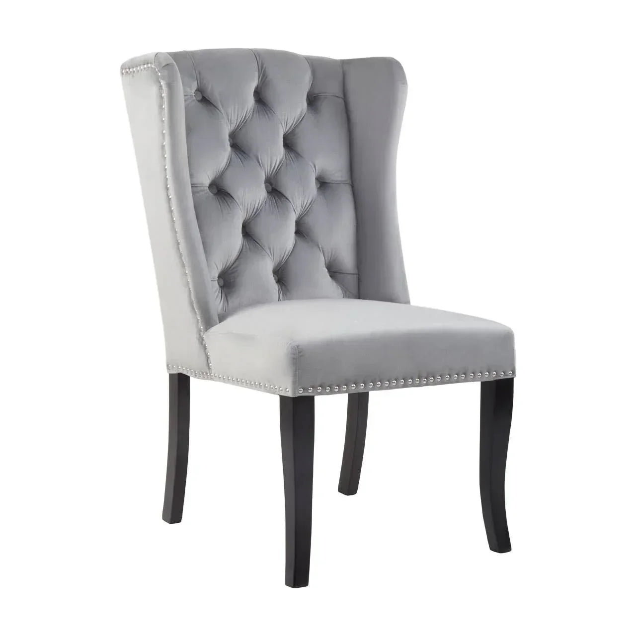 Grey velvet dining chair with button-tufted backrest, silver stud trim, and dark wooden legs