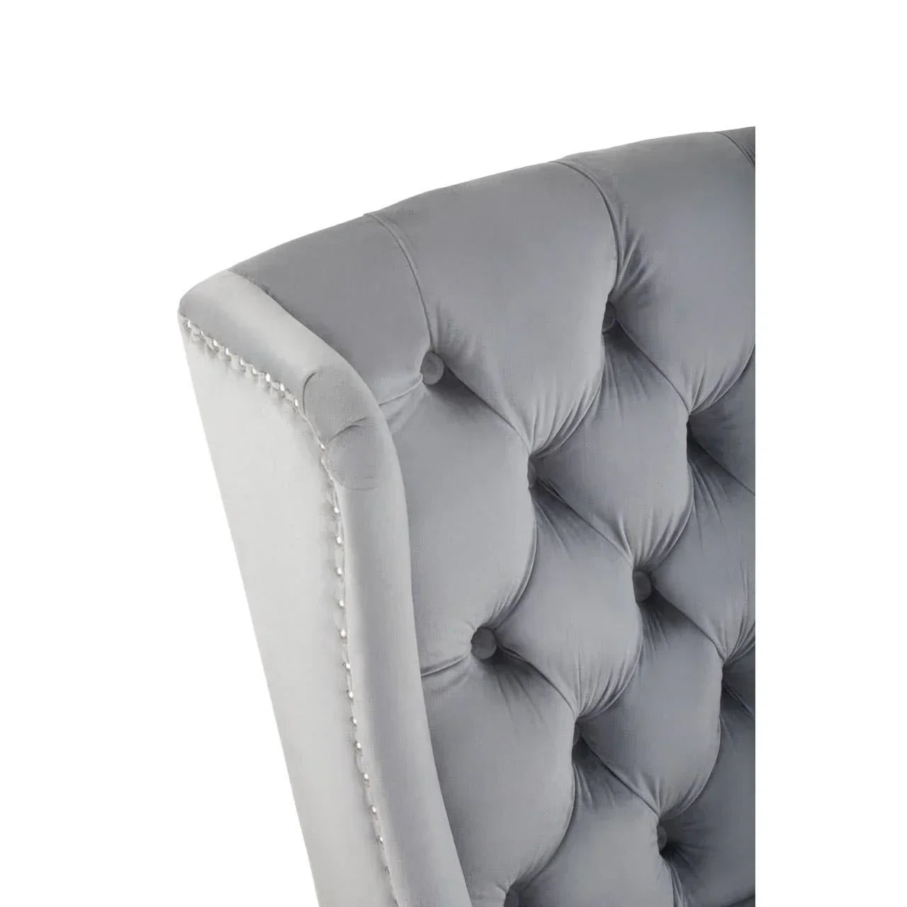 Grey velvet dining chair with deep button tufting and silver studded trim detail