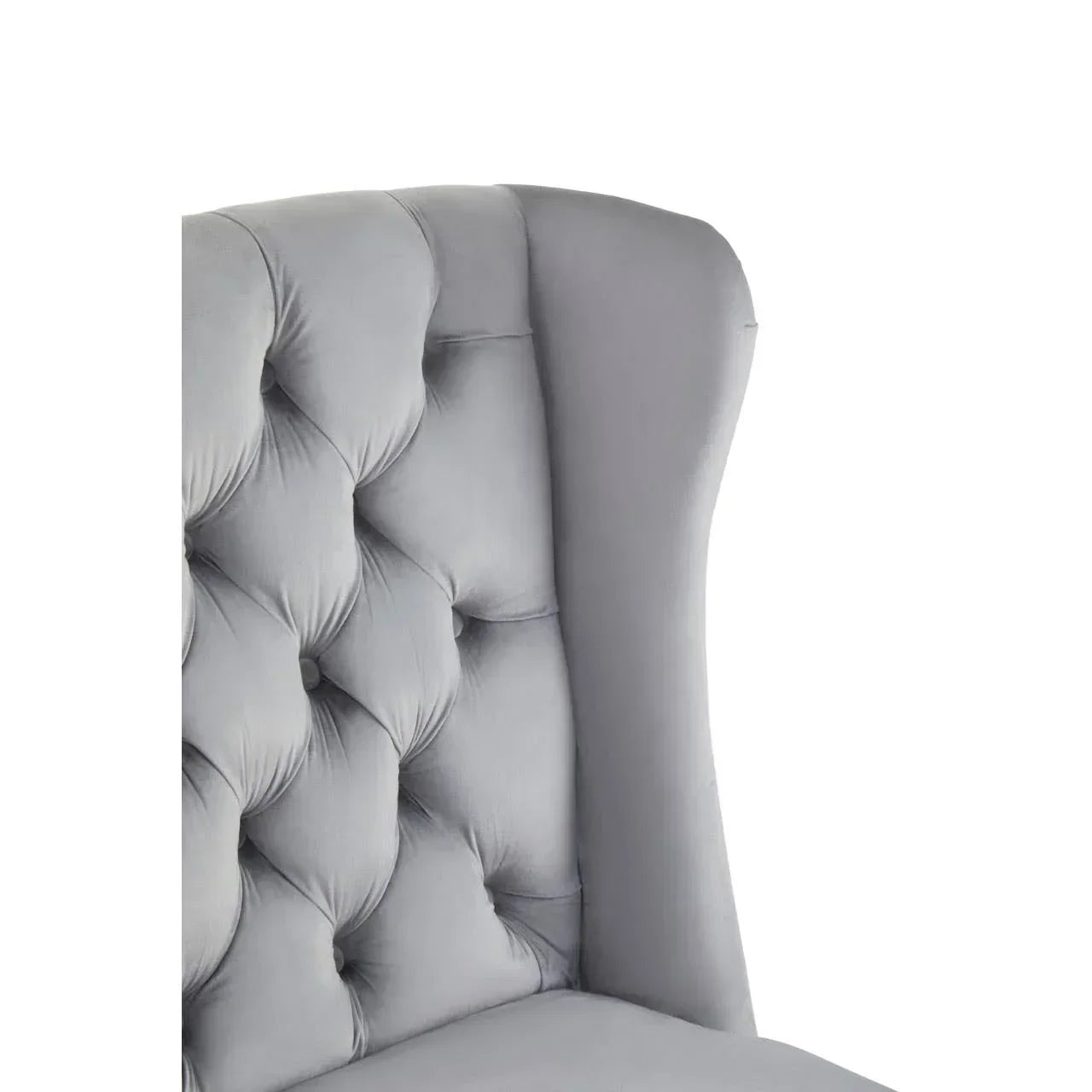 Grey velvet dining chair with tufted backrest and high winged sides close view