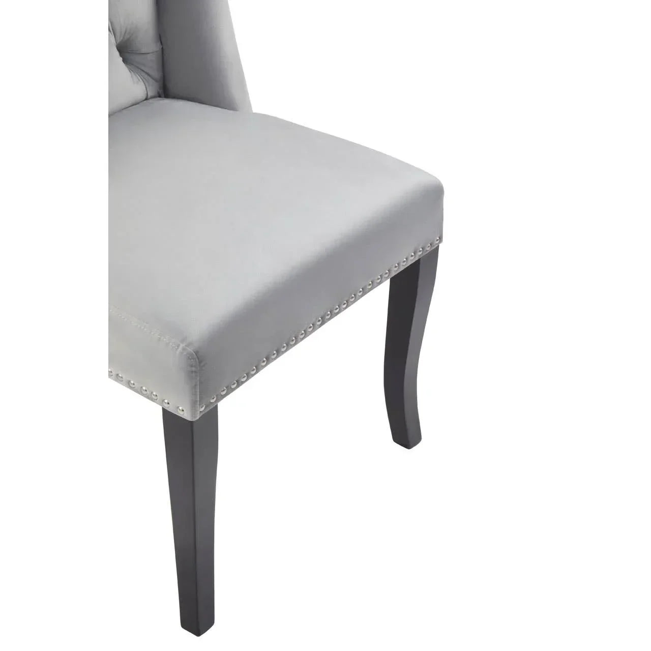 Light grey upholstered dining chair with silver stud trim and dark wooden legs