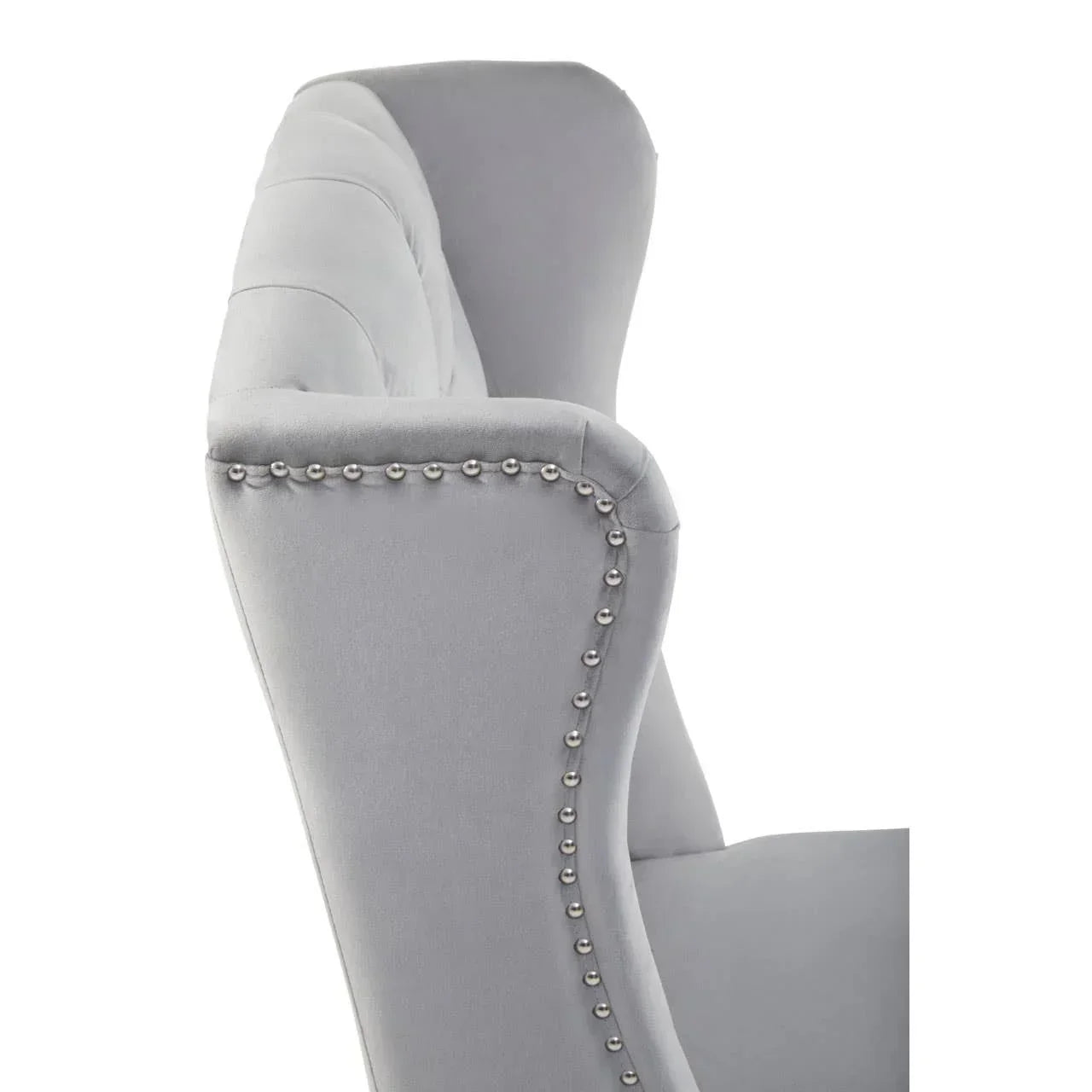 Closeup of grey velvet armchair with silver stud detailing on side