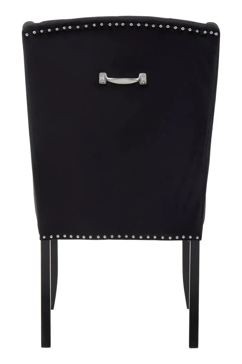 Black upholstered dining chair with silver stud detailing and metal pull handle, rear view