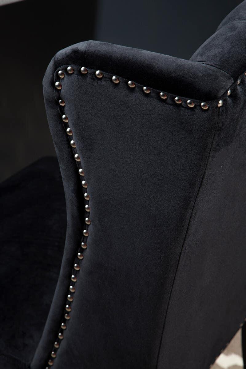Black velvet dining chair with silver studded trim, close-up of arm and backrest
