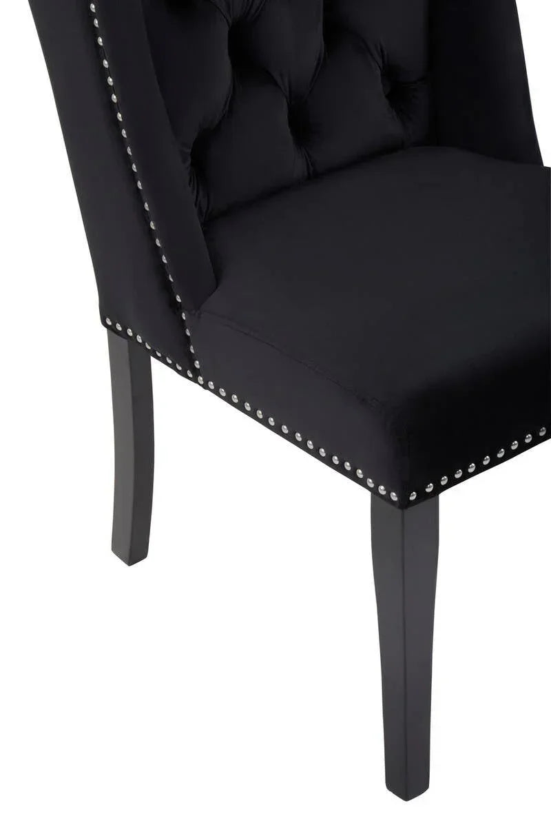Black upholstered dining chair with button-tufted backrest and silver stud detailing