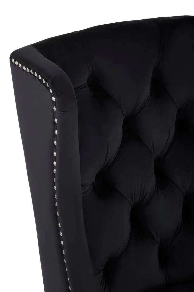 Black velvet armchair with button-tufted back and silver studded trim detail