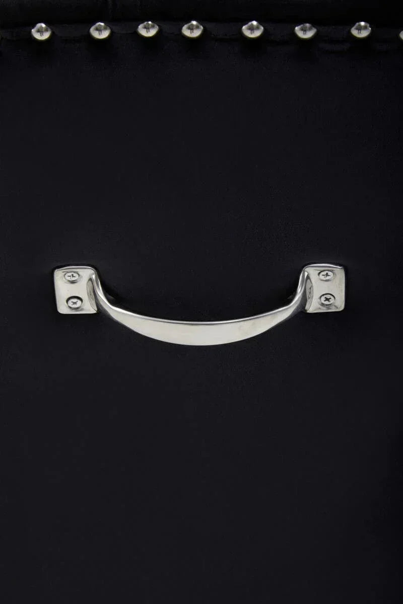 Close-up of silver metal handle and stud detail on black furniture drawer front
