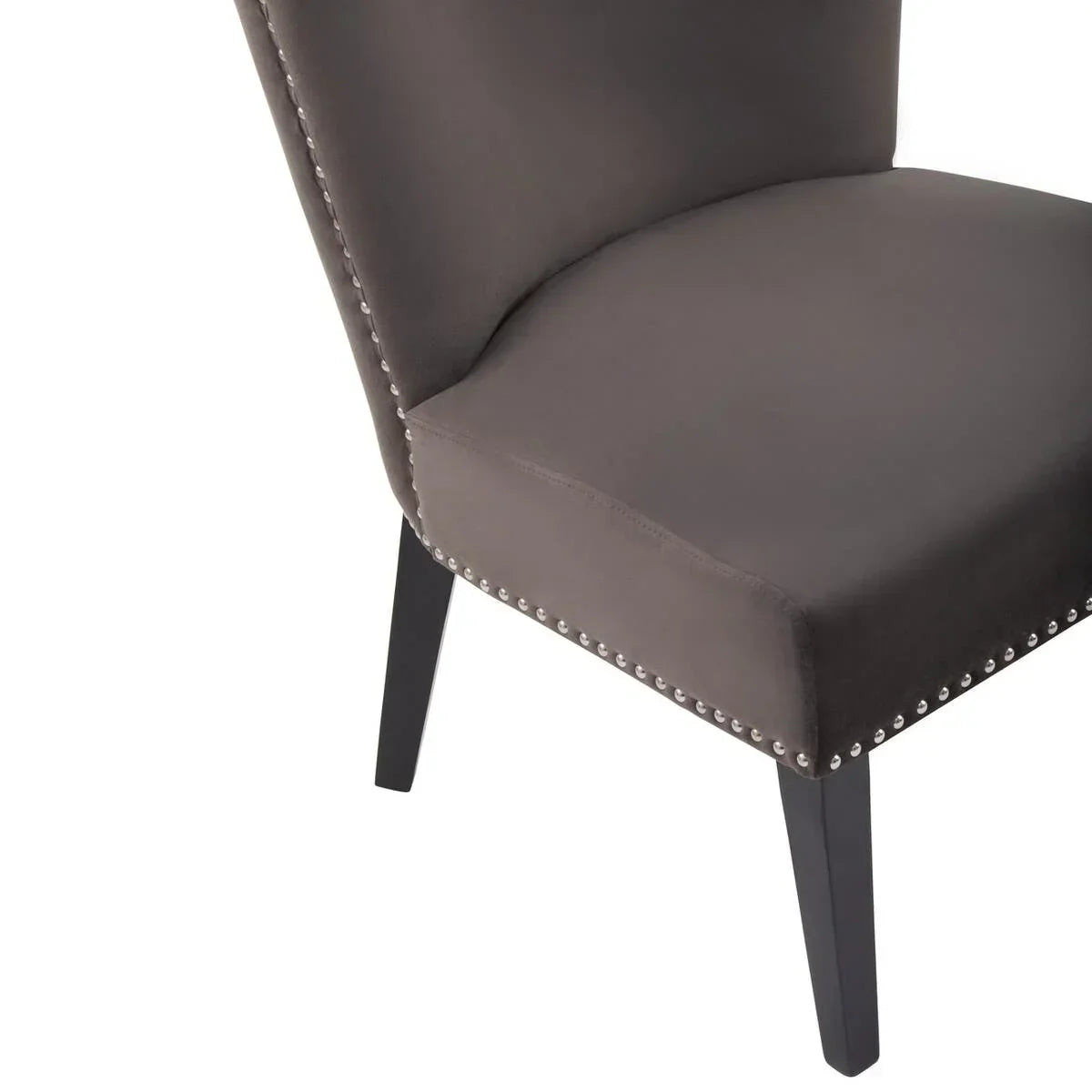 Grey velvet dining chair with silver stud trim and black wooden legs, angled front view