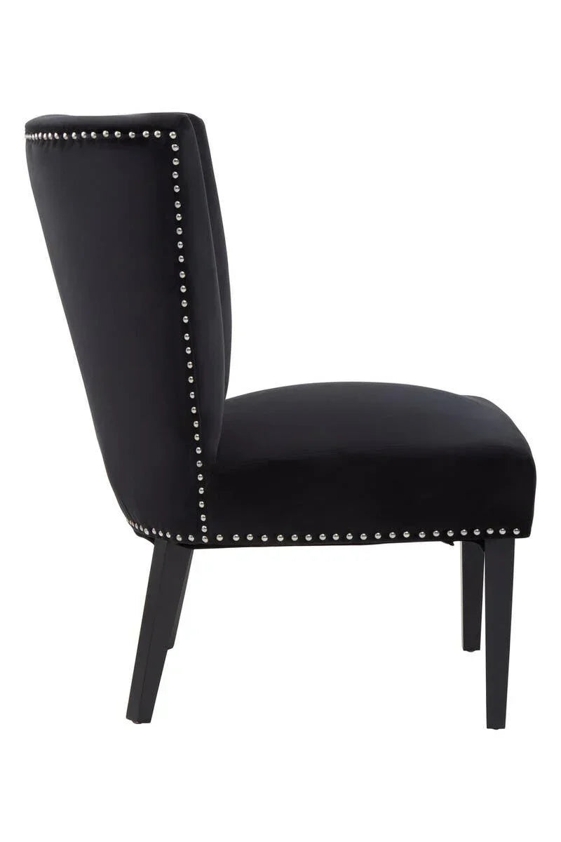 Black velvet accent chair with silver studded trim and dark wood legs, side view
