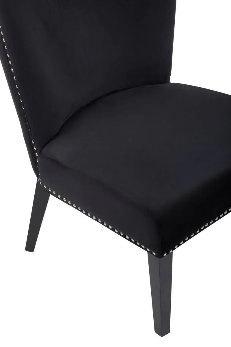 Black velvet dining chair with studded trim and dark wooden legs, side view