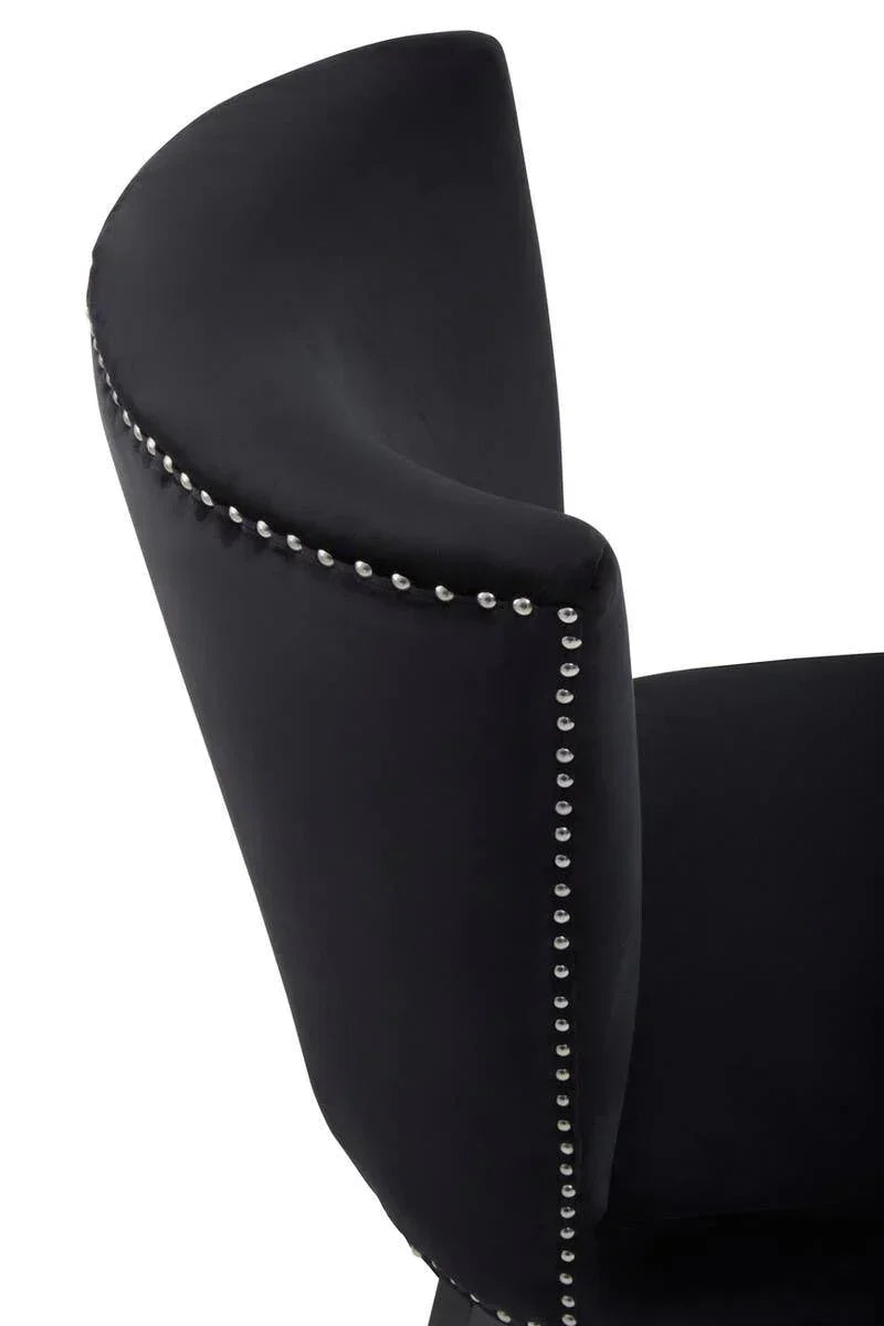 Black velvet dining chair backrest with silver stud detailing, angled close-up view