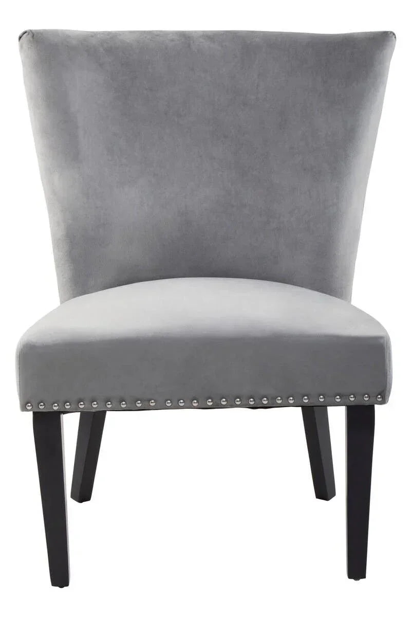 Grey velvet accent chair with flared backrest, black wood legs and stud detailing on seat edge