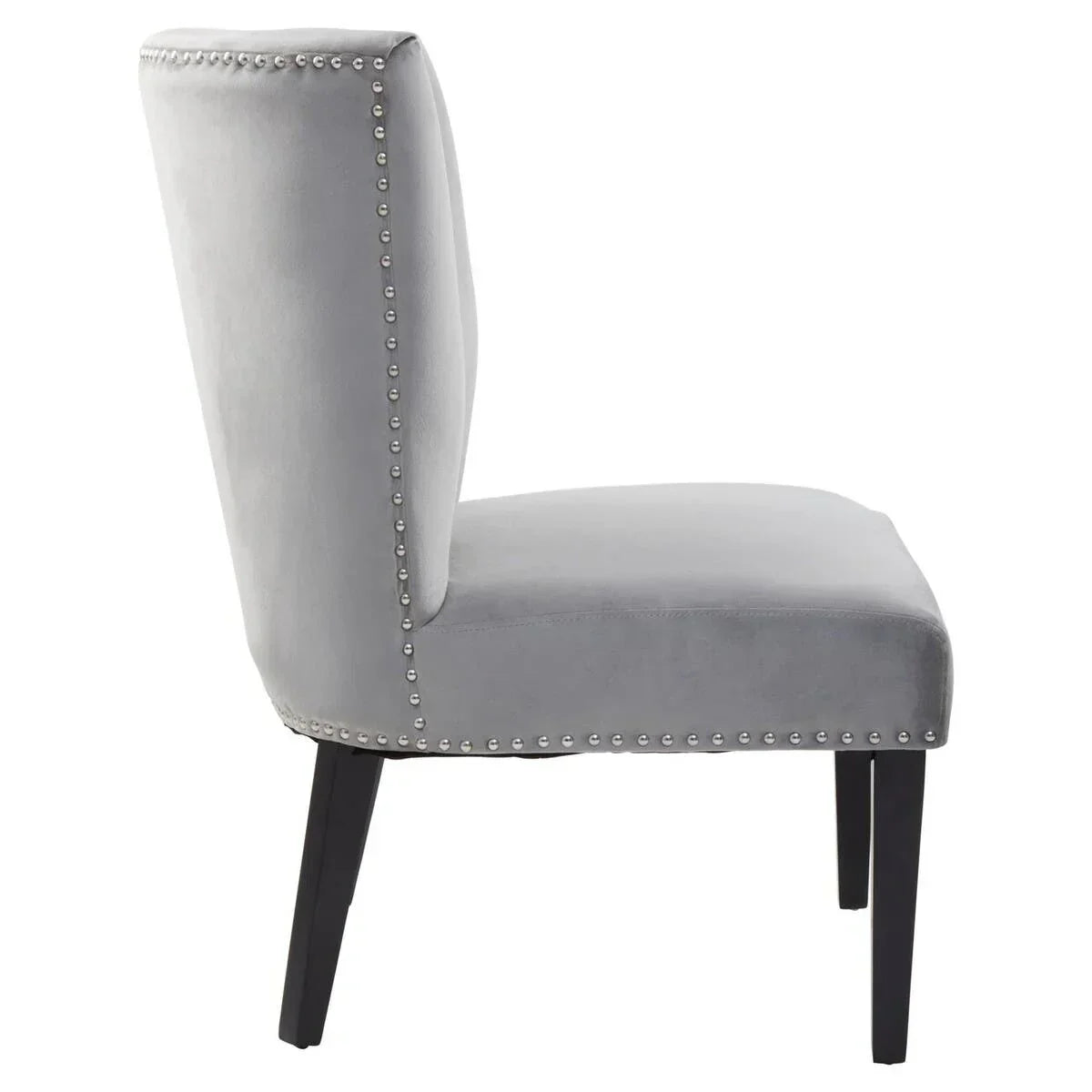 Grey velvet accent chair with silver stud trim and black wooden legs, side profile view
