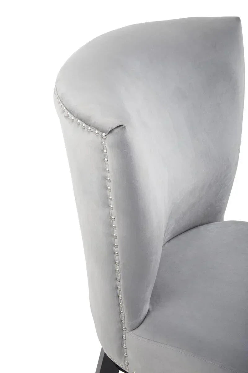 Light grey velvet dining chair with silver stud detailing on backrest and side
