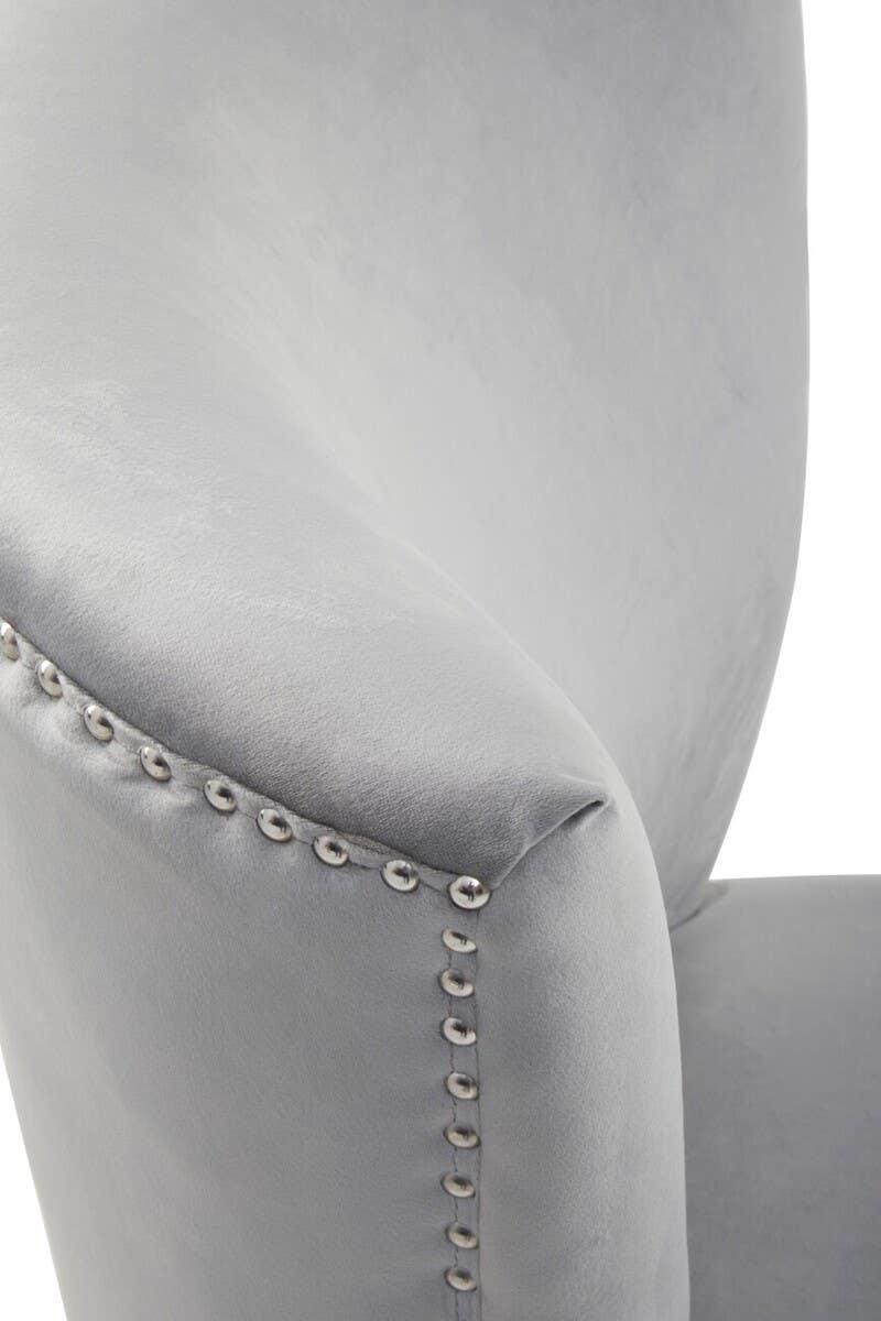 Light grey velvet chair armrest with silver stud detailing, close-up view