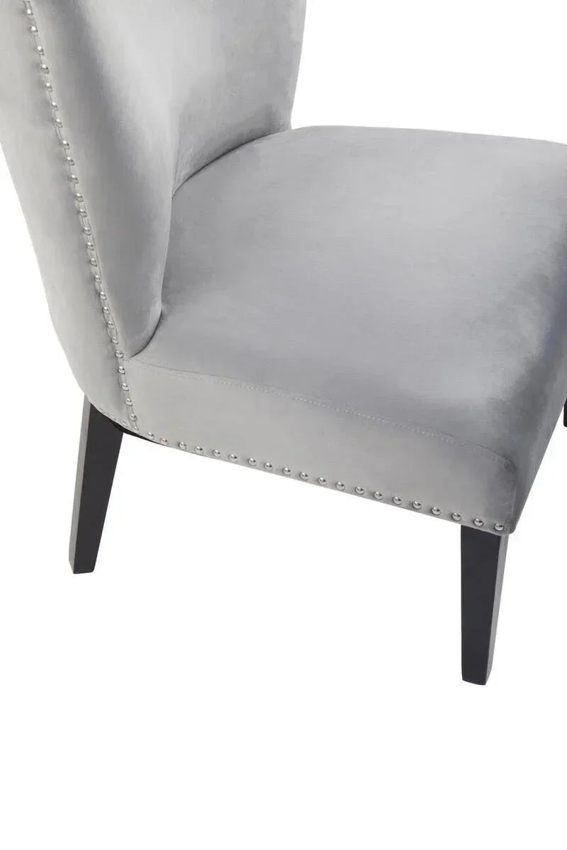 Light grey velvet dining chair with silver stud detail and black wooden legs