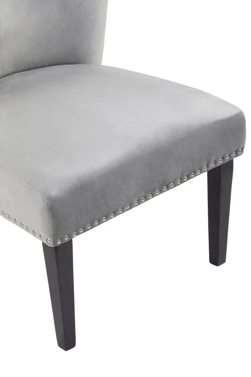 Grey velvet dining chair with silver stud detailing and dark wooden legs