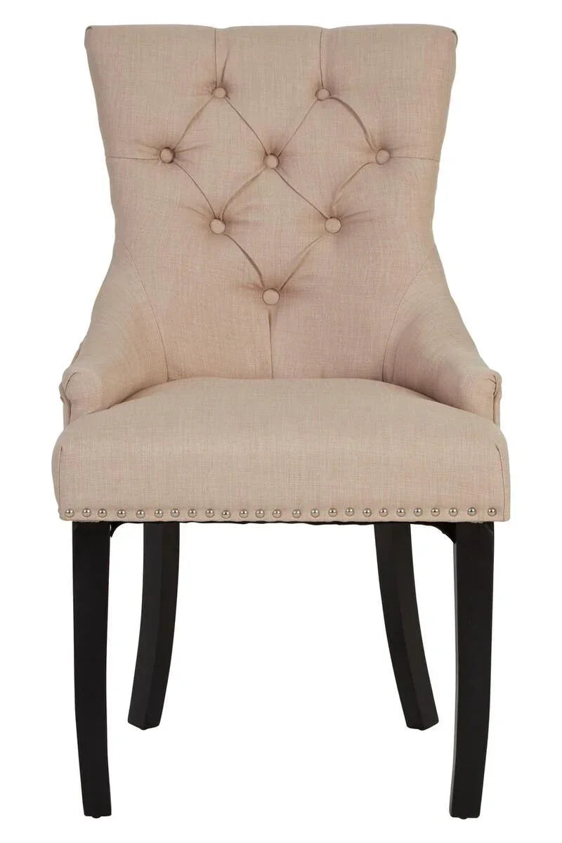 Beige upholstered dining chair with button tufted back and dark wooden legs