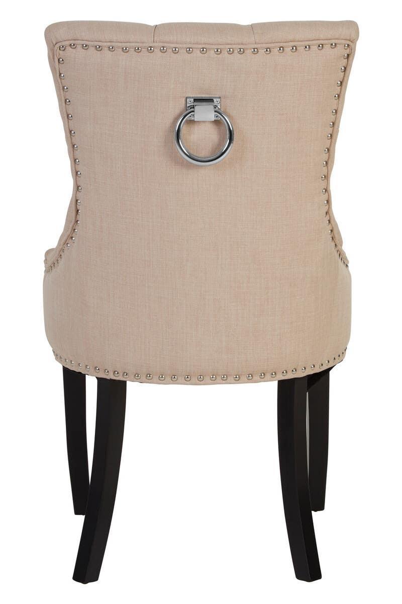 Beige upholstered dining chair with silver ring handle and nailhead trim, rear view