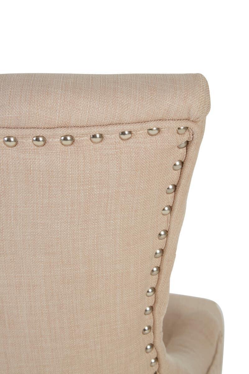 Beige fabric dining chair with silver stud detailing on the backrest