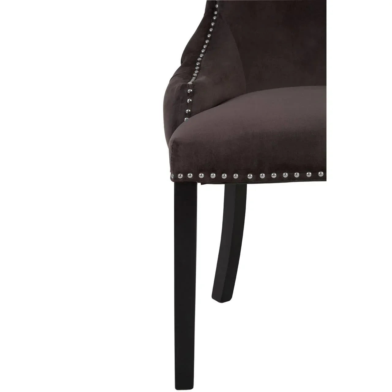 Dark velvet dining chair with silver stud trim and black wooden legs, close-up side view