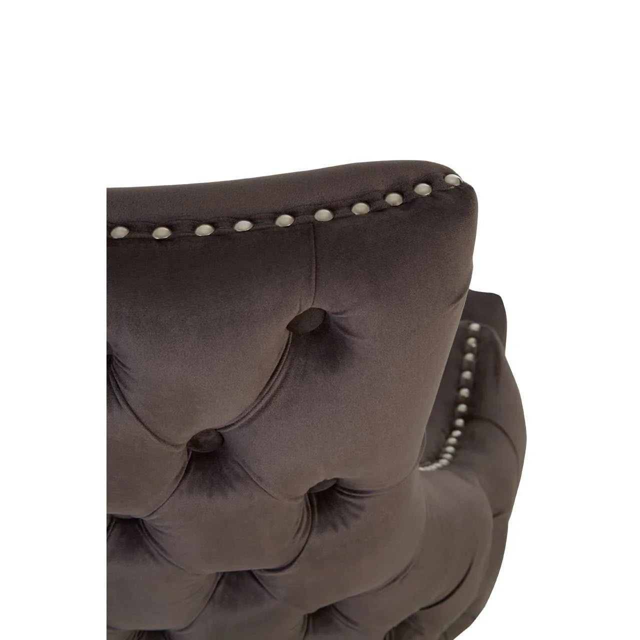 Dark tufted velvet chair back with silver stud detail and plush upholstery