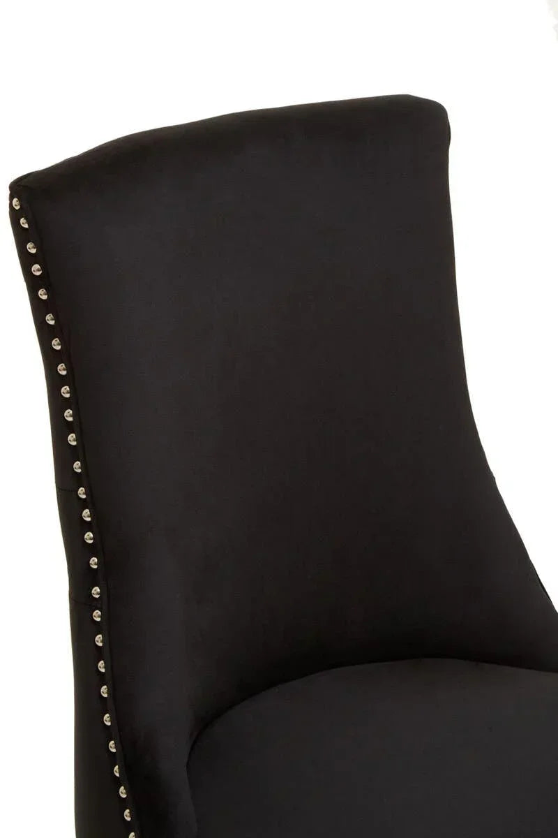 Black dining chair with silver stud detailing on backrest, close-up view