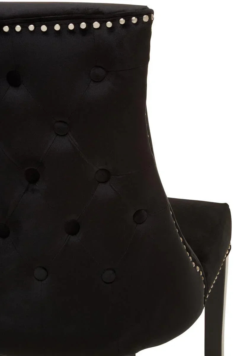 Black velvet dining chair with button-tufted back and silver stud trim, rear view