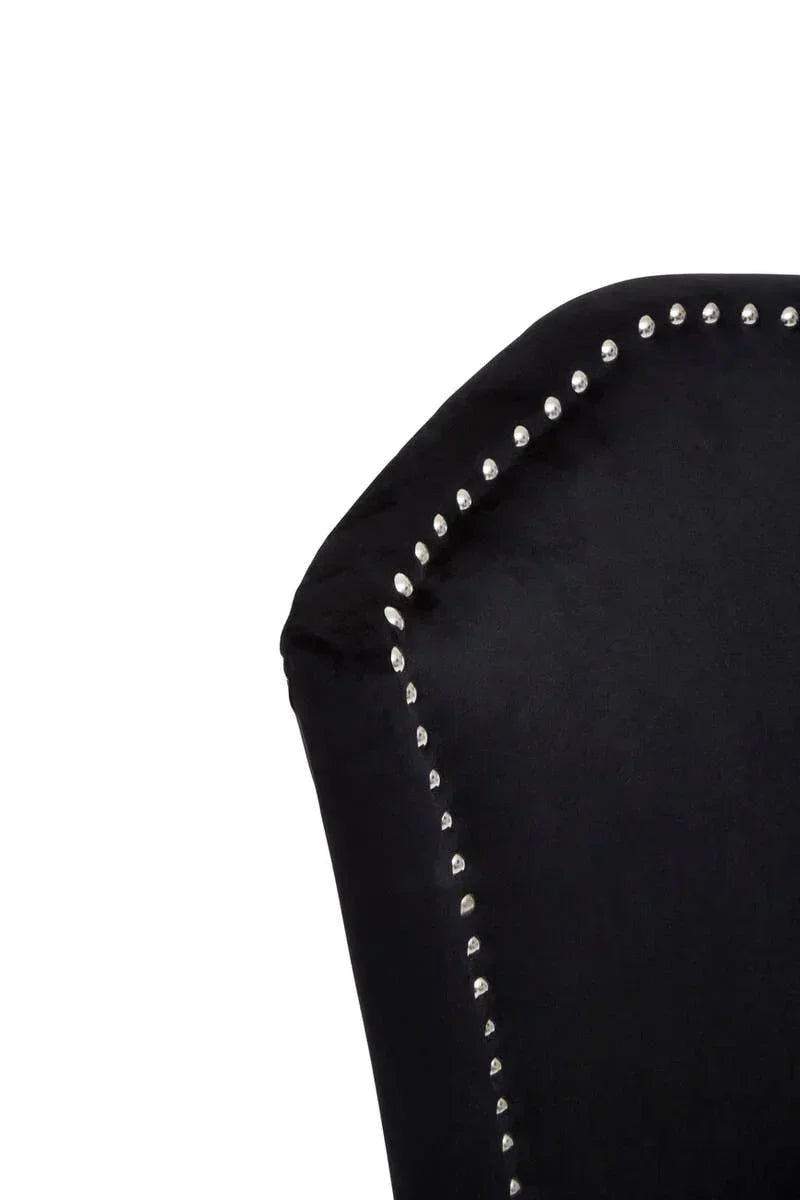 Close-up of black velvet dining chair with silver studded trim on backrest