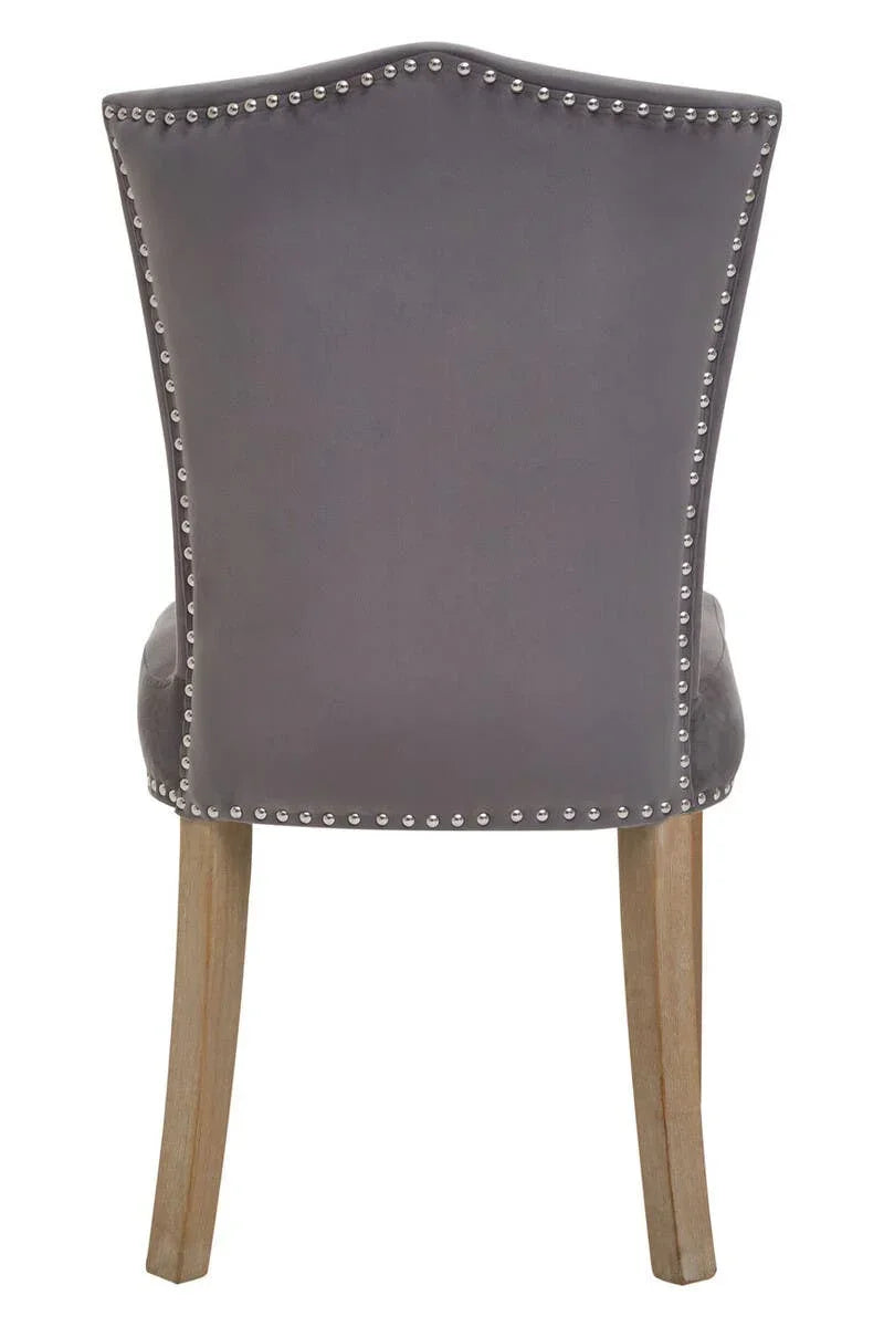 Grey velvet dining chair with silver stud detailing and light wooden legs, rear view