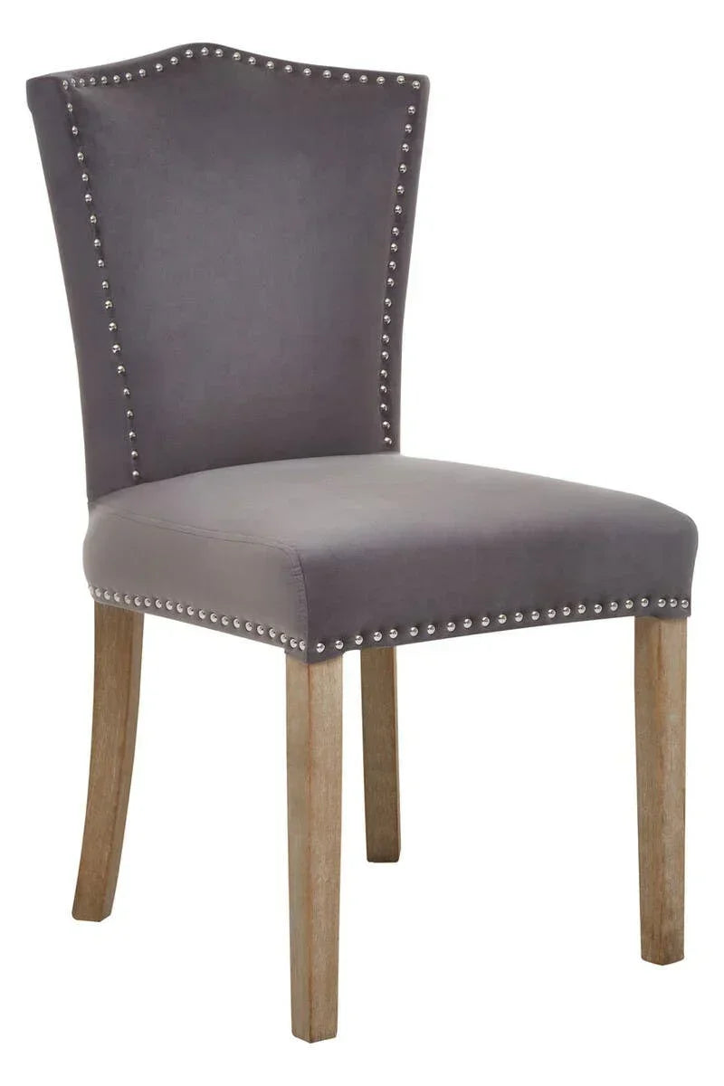 Grey upholstered dining chair with studded trim and wooden legs
