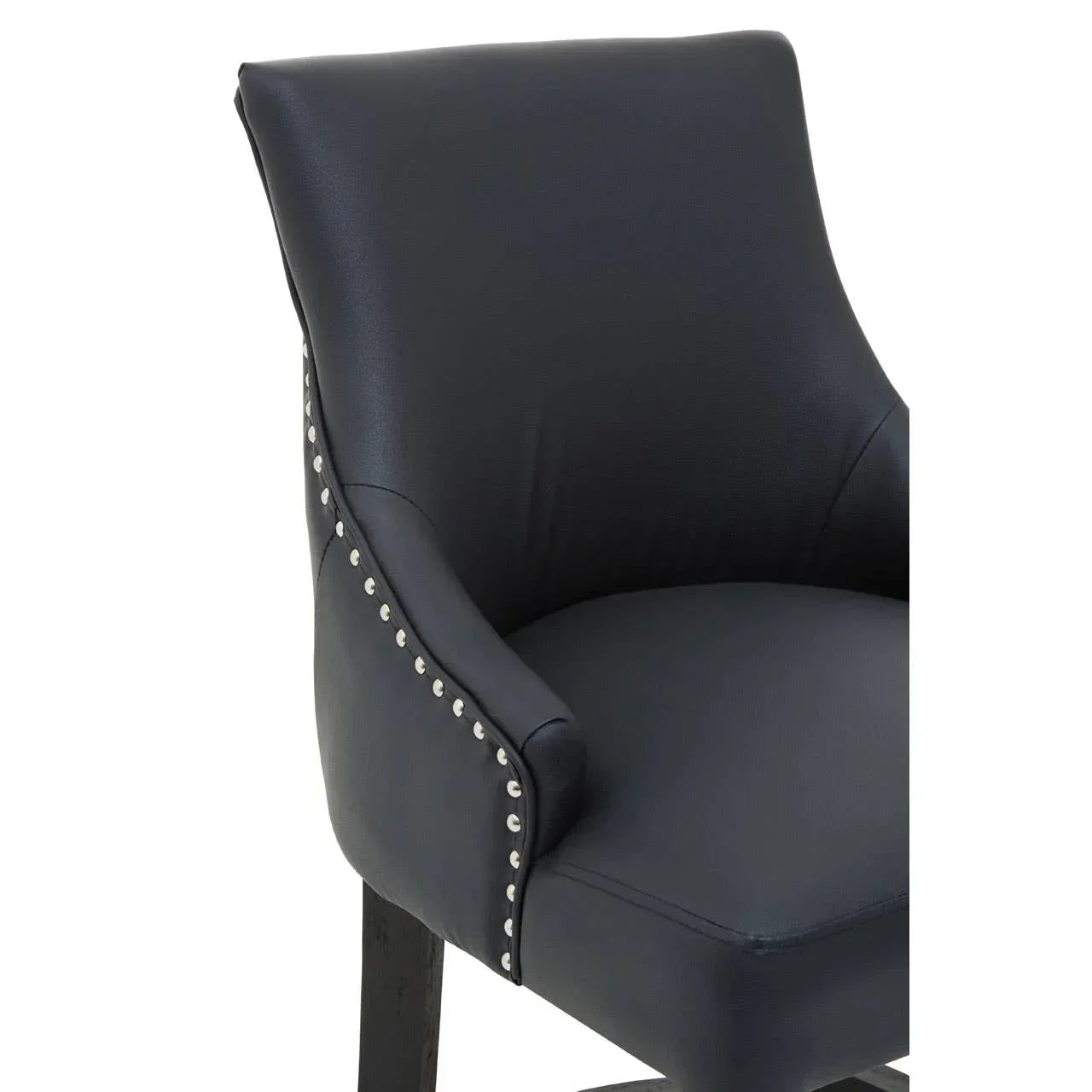 Black faux leather dining chair with silver stud detailing and wooden legs, side angle view