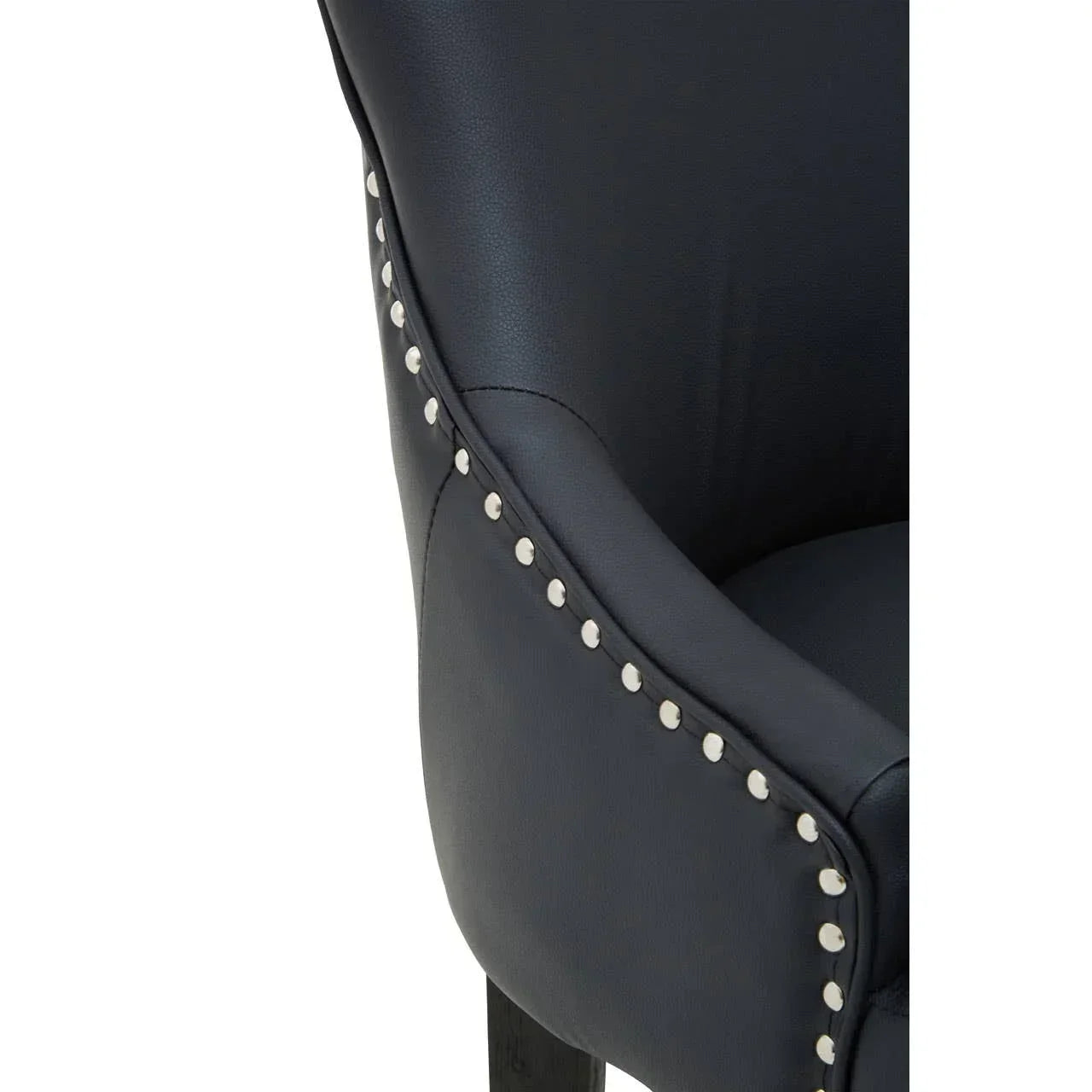 Black leather dining chair close-up with silver stud detailing along the armrest