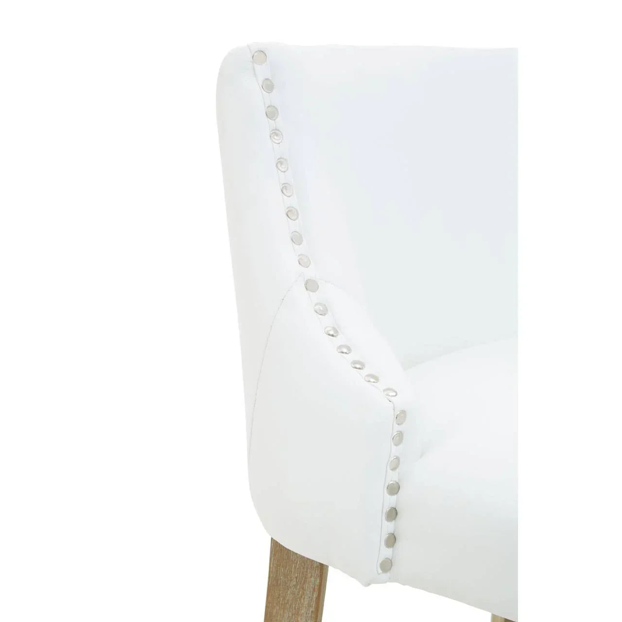 White upholstered dining chair with metal stud detailing and wooden leg, side angle view