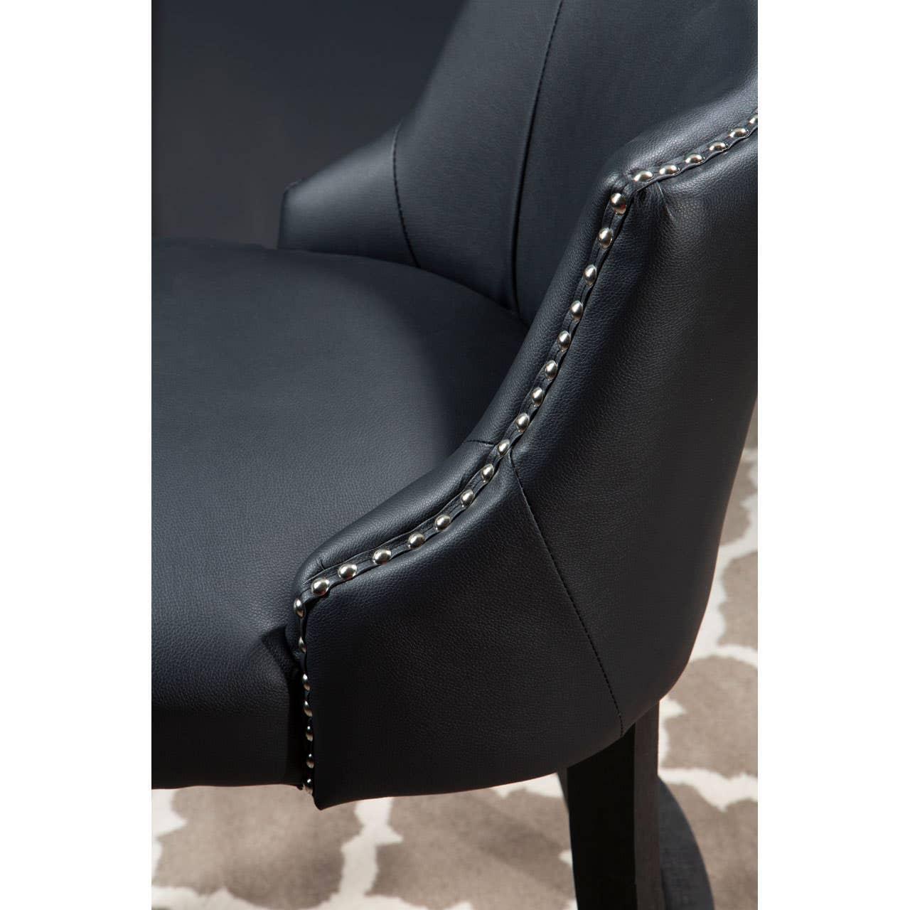 Black leather armchair with silver stud detailing on armrest, close-up view