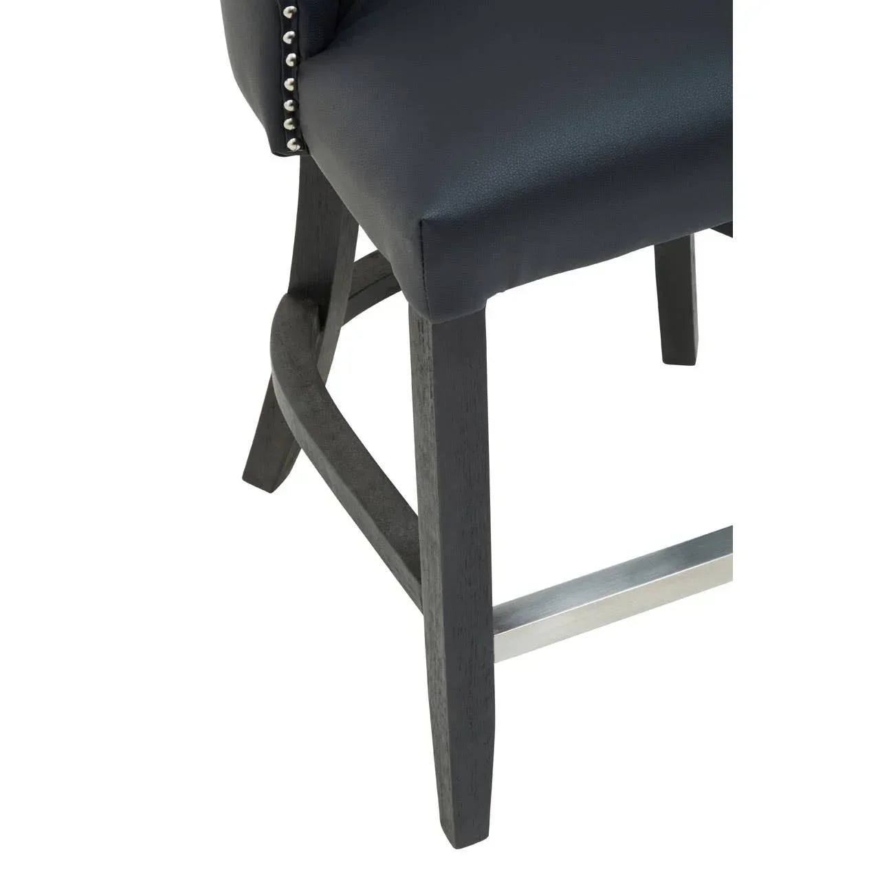Black leather bar stool seat with stud detailing and dark wooden legs, close-up view