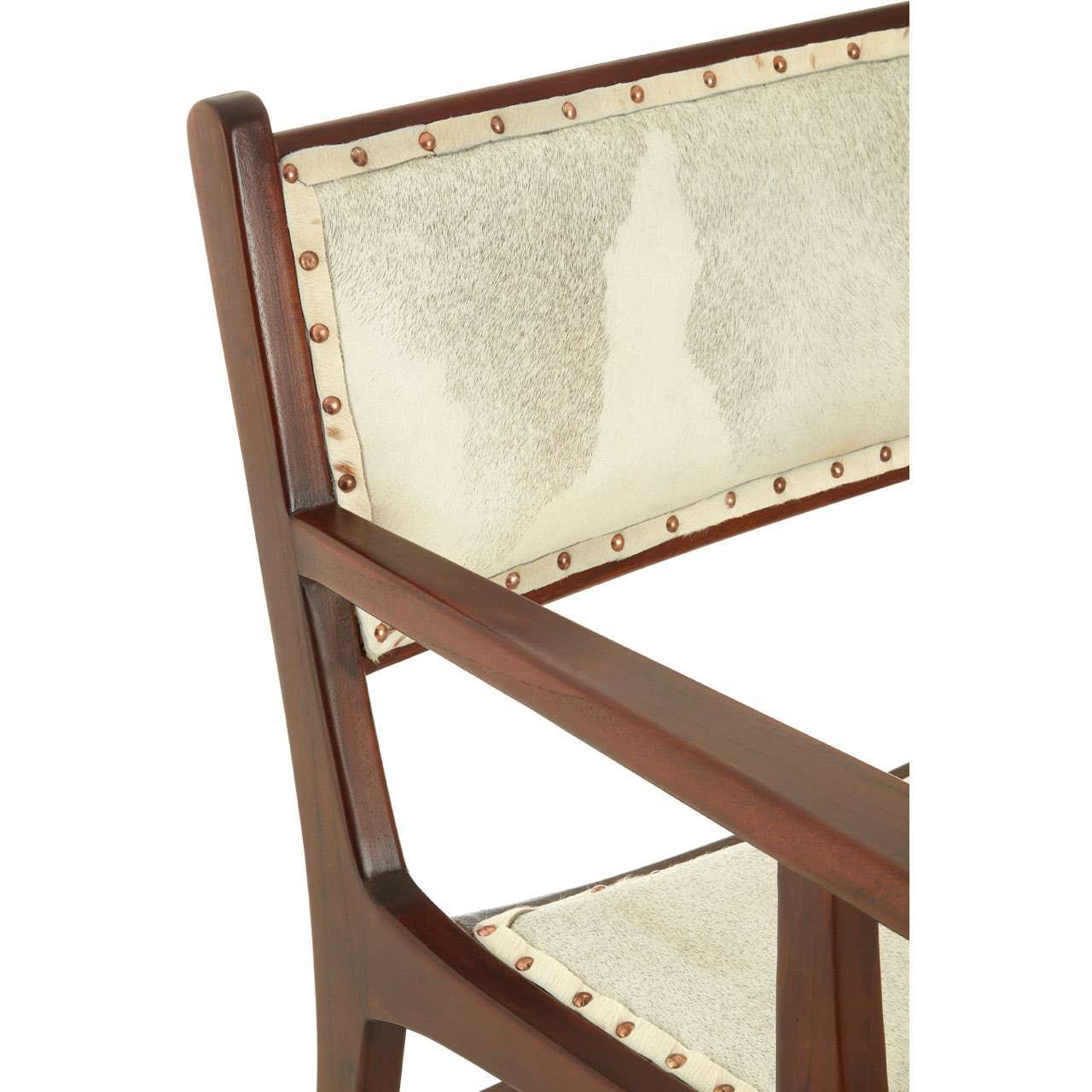 Wooden chair with cream cowhide upholstery and brass stud detailing on backrest and seat