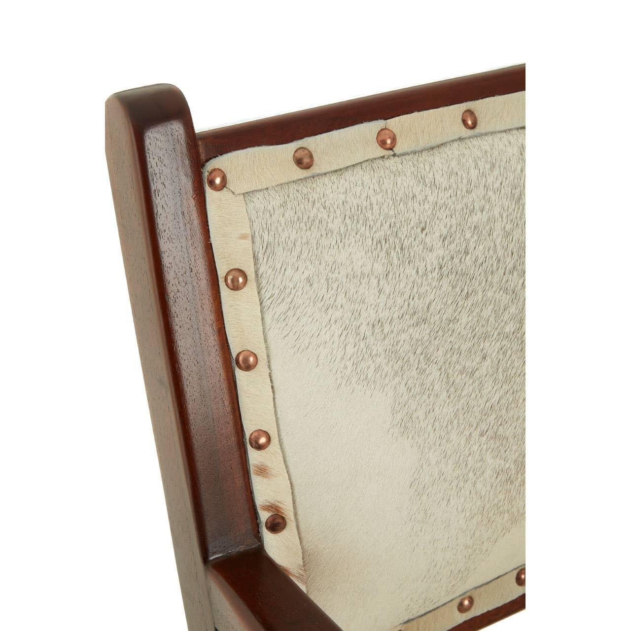 Wood chair back with natural cowhide upholstery and bronze stud detailing