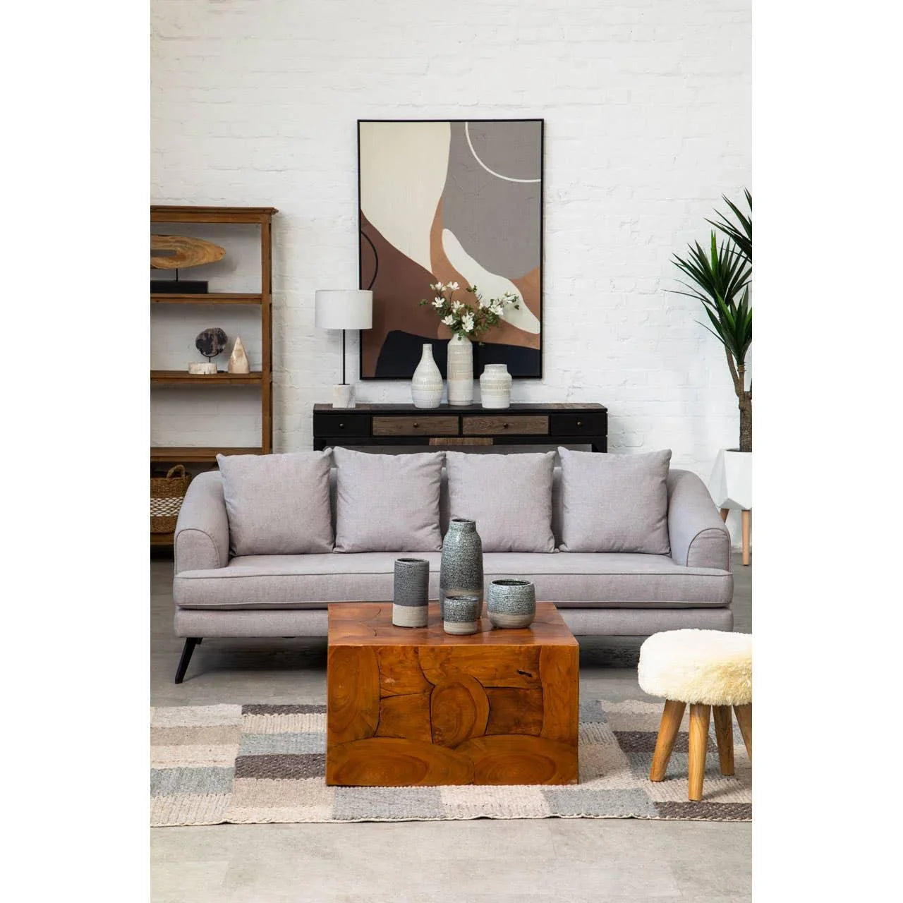 Light grey fabric sofa with cushions, wood coffee table and modern decor in living room