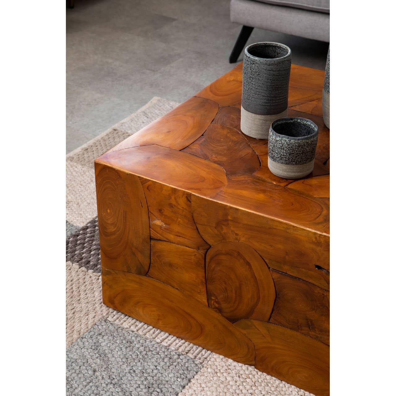 Solid wood coffee table with natural grain detail and stoneware vases on textured rug