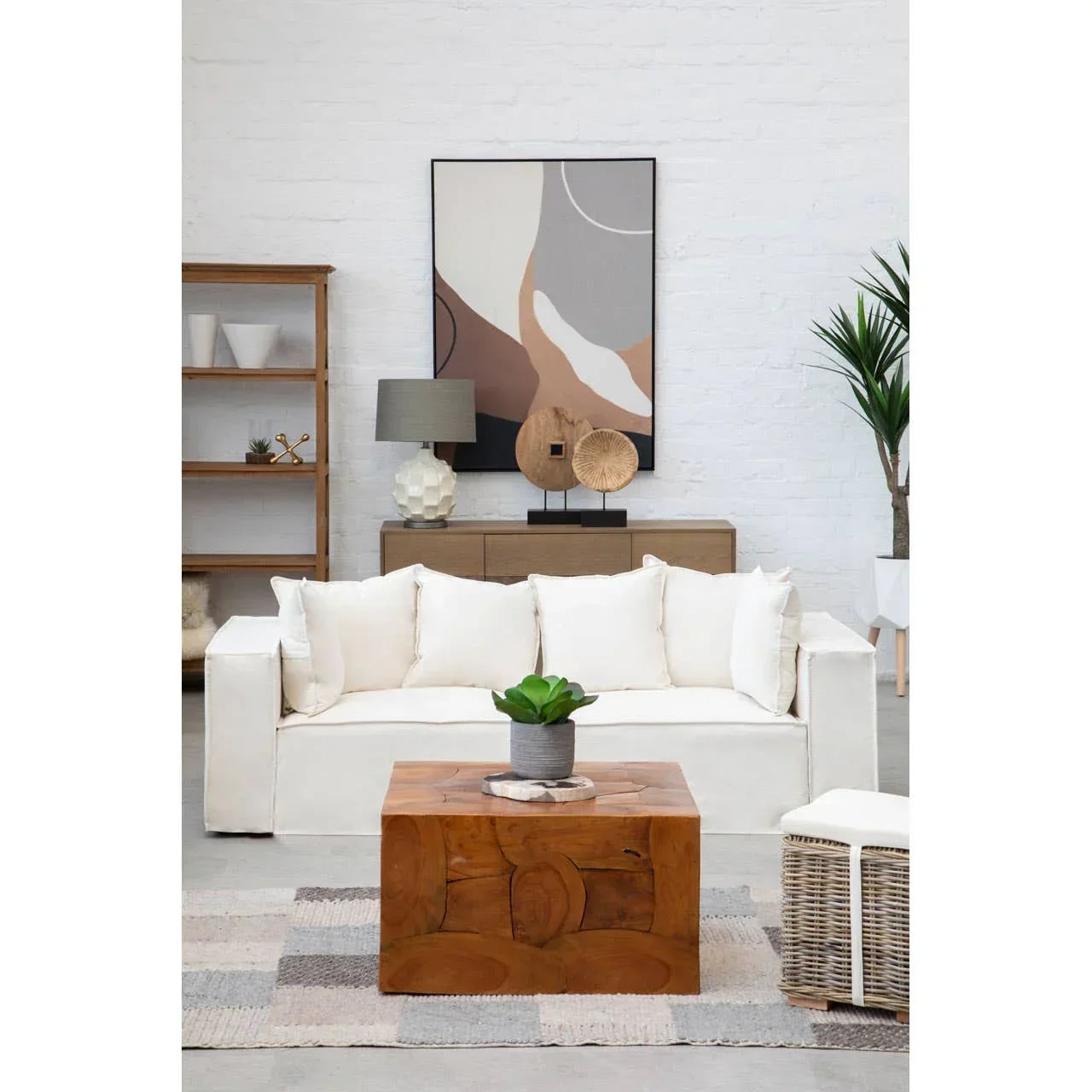 White fabric sofa with cushions and solid wood coffee table in modern living room setting