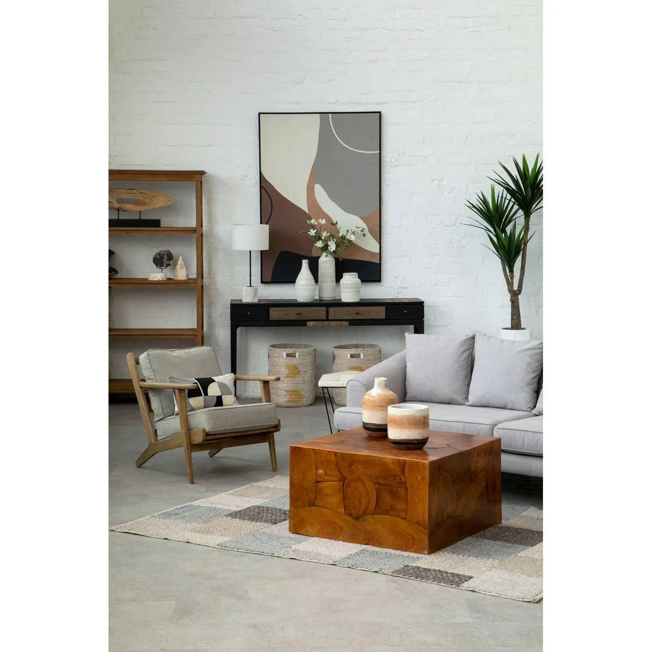 Modern living room with grey sofa, wooden coffee table, accent chair, and abstract wall art
